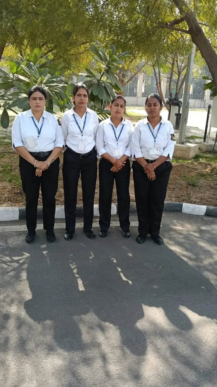 Four SMSA women personnel in white shirts and black trousers with ID badges standing outdoors