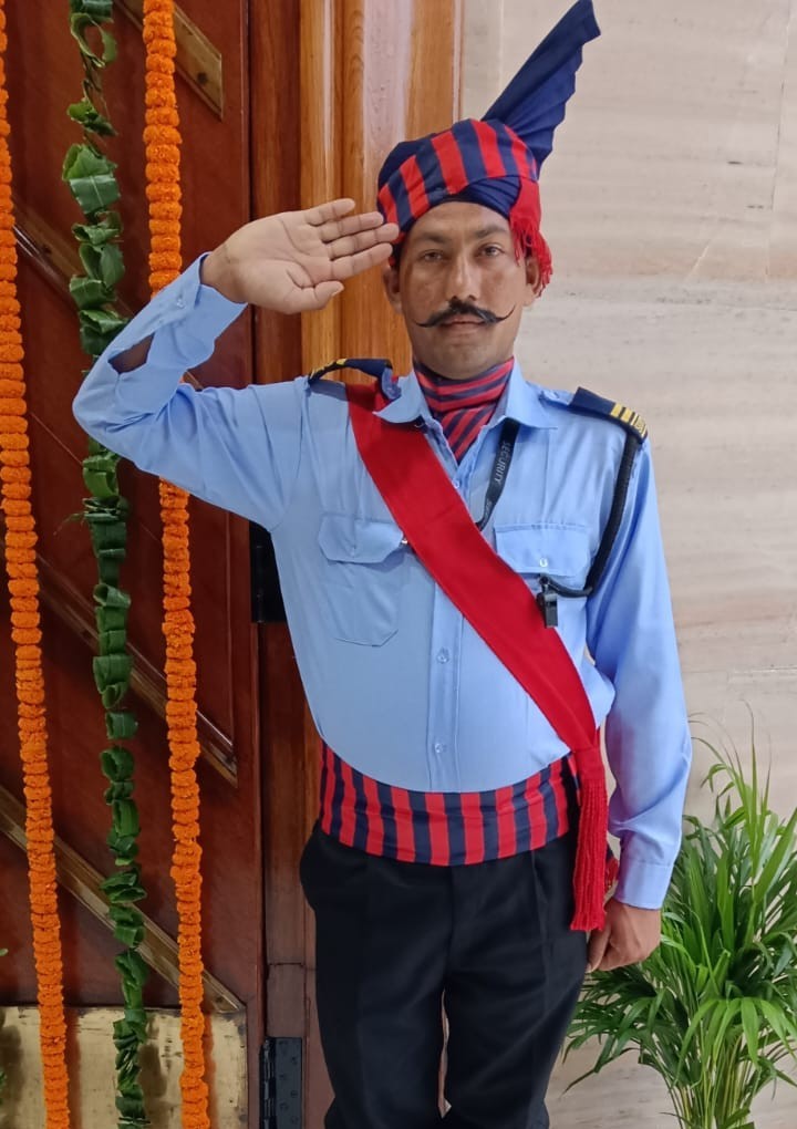 Security guard in ceremonial uniform saluting near a decorated entrance